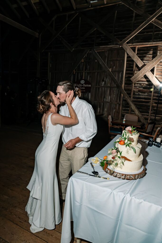 Bride and groom cutting their wedding cake at The Homestead Farm barn reception