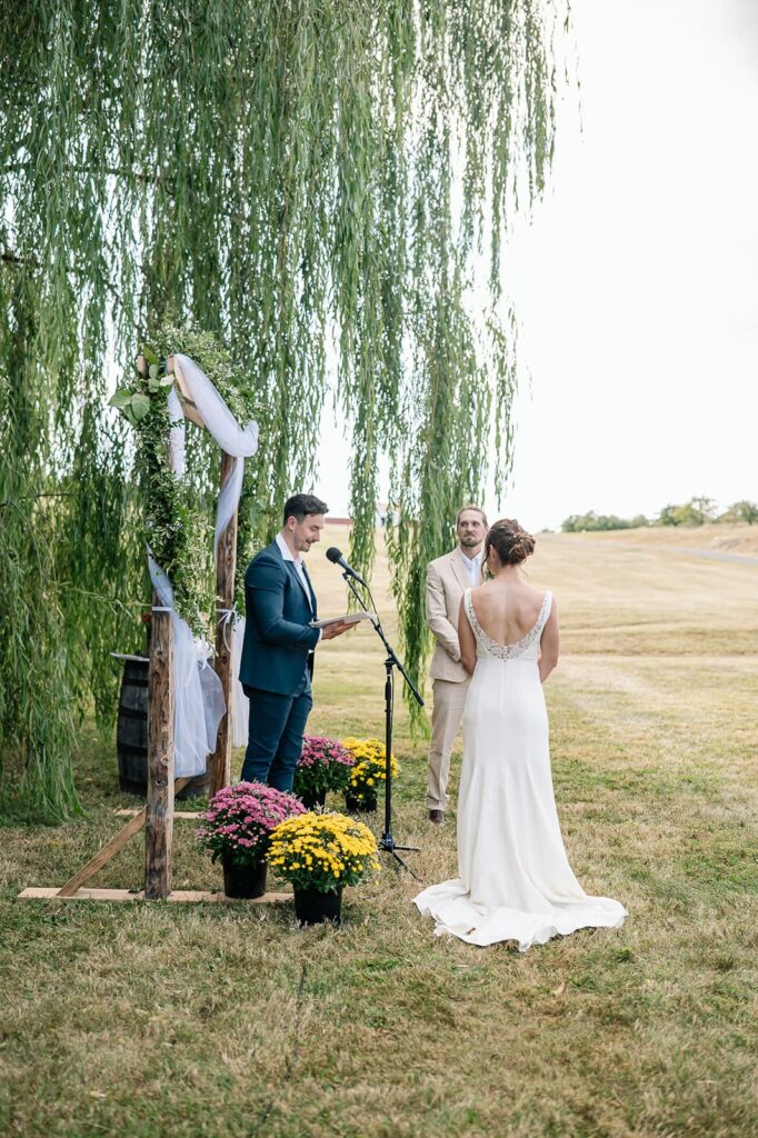 Bride and groom exchanging vows at an outdoor ceremony at The Homestead Farm