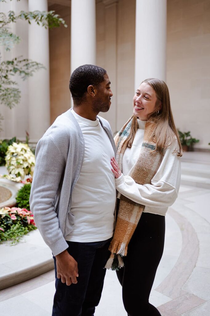 Couple standing beneath architectural arches at the National Gallery of Art DC