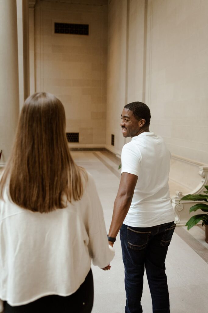 Engagement photos at the National Gallery of Art in Washington DC with couple walking indoors